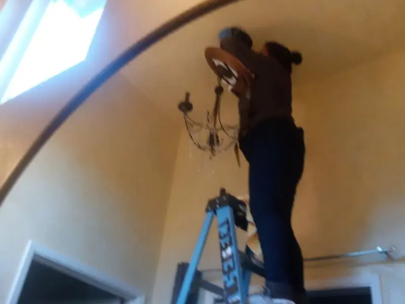Electrician installing a chandelier in a Wenatchee residence